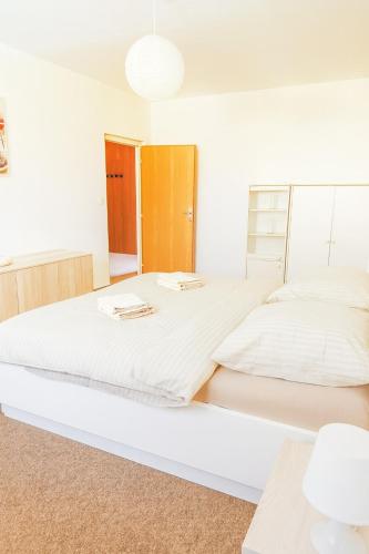 a white bedroom with a large white bed at Apartmán MONTARA 23 in Donovaly