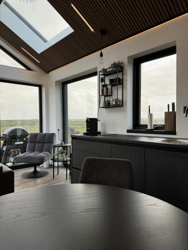a dining room with a table and two windows at LL Properties - Aurora Lodges in Grímsnes og Grafningshreppur