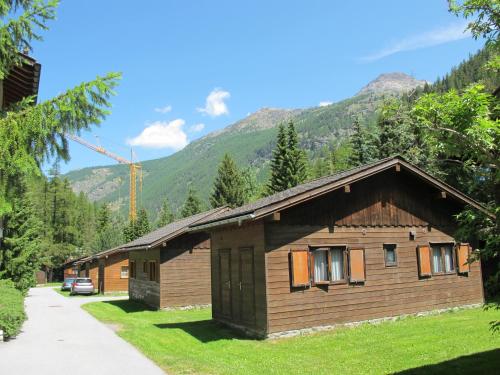 a log cabin with a mountain in the background at Residenz Edelweiss SAAS312 in Hollerbiel