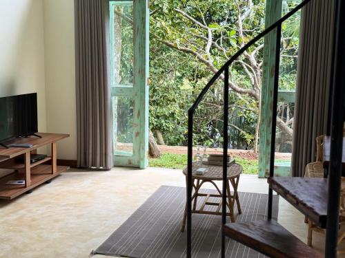 un salon avec une chaise et une grande fenêtre dans l'établissement Onilwe Resort Weligama, à Weligama