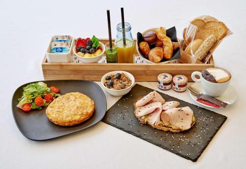 una mesa con dos platos de comida y una bandeja de pan en NH Collection Madrid Gran Vía, en Madrid
