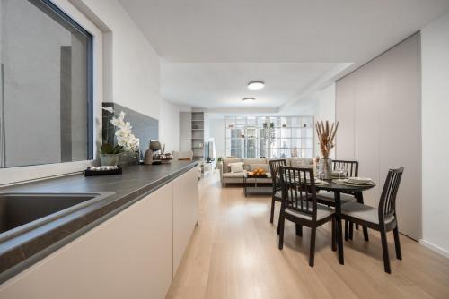 a kitchen and dining room with a table and chairs at LAM Cream Old Town Balcony & AC in Bratislava