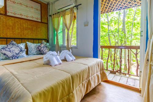 Ko Lanta YaiにあるLe Panpurie Koh Lanta Resortのベッドルーム1室(窓のあるベッド1台にタオル2枚付)