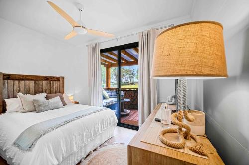 Mitchells IslandBelgravia Bungalow-Hear the Ocean, See the Stars的卧室里有一张床和一张带灯的桌子