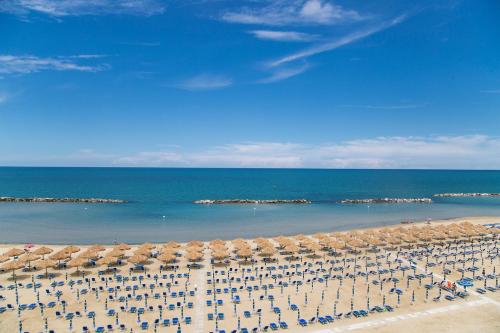 a beach with a lot of chairs and umbrellas at Hotel Mara in Ortona