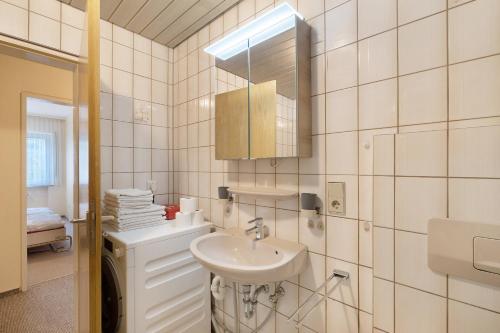 a white bathroom with a sink and a mirror at Ferienwohnung Matteit in Bad Peterstal