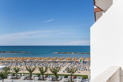 a view of the beach with chairs and umbrellas at Hotel Mara in Ortona