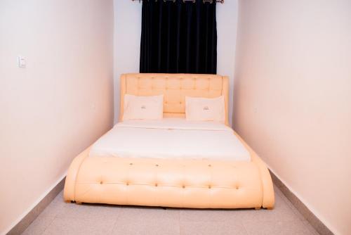 ein gelbes Bett in einem Zimmer mit einem schwarzen Fenster in der Unterkunft The Moon Geust House in Gisenyi