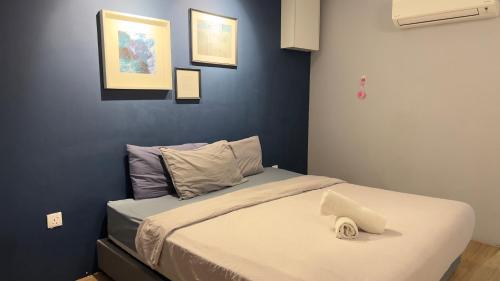 een bed in een kamer met een blauwe muur bij Marbella in Kuala Lumpur