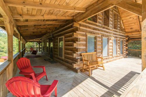 a log cabin porch with red chairs and a wooden ceiling at Hot Tub & WiFi - Big Boulder - Red River Gorge KY in Rogers