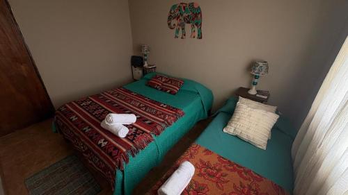 two twin beds in a small room with towels at Hotel Cabañas Aparts Tierra de Glaciares in El Calafate