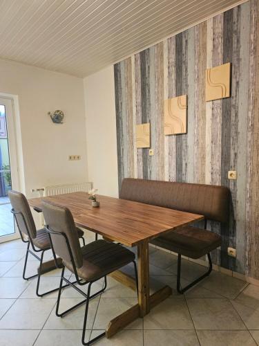 a wooden table and chairs in a room at Roschi's Gästehaus in Gudow