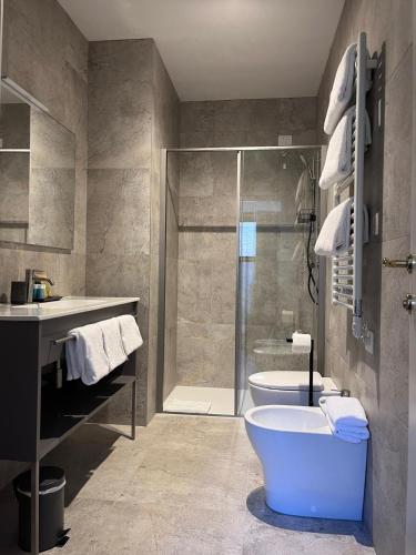 a bathroom with a shower and a toilet and a tub at Casanova Hideaway in Venice