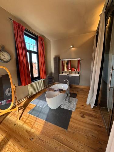 een badkamer met een bad op een houten vloer bij Maison du Rempart in Brugge