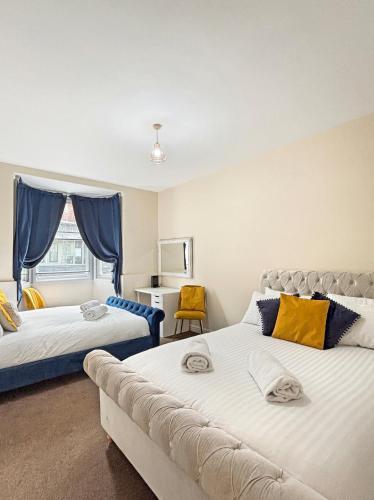a bedroom with two beds and a couch at Spacious Central Ground Floor Apartment Sleeps 6 - Newark Town Centre - Free Parking - Amaya Twelve in Newark upon Trent