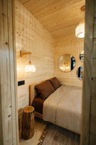 a bedroom with a bed in a wooden room at Forest Vibe Hotel&Spa in Kulʼchin