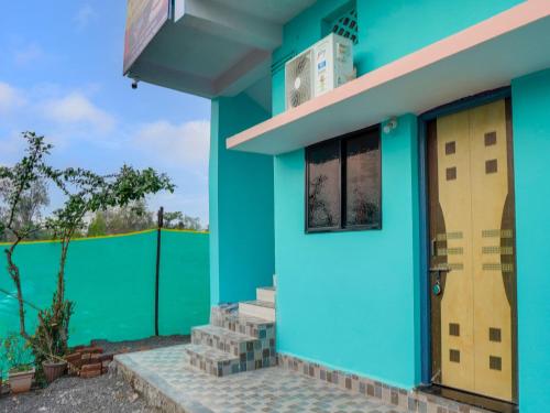 a blue house with a blue door and a green fence at Hotel O Kanha in Nagpur