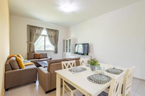a living room with a table and a couch at Peaceful and Spacious 2 BDR in the Heart of Al Ghadeer Community in Ghantoot