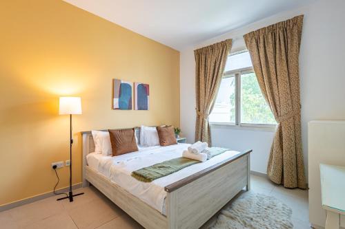 Un dormitorio con una cama y una ventana en Peaceful and Spacious 2 BDR in the Heart of Al Ghadeer Community, en Ghantoot