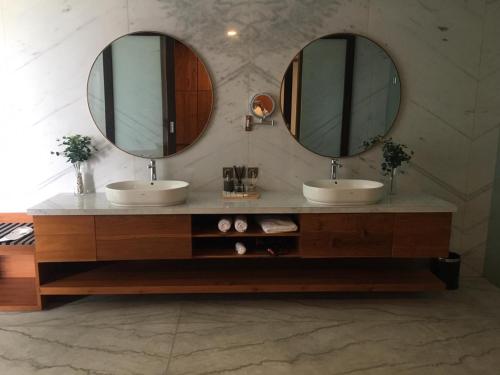 two sinks in a bathroom with two mirrors at M Villa in Bingin Beach
