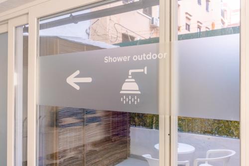 a sign on a window of a shower outdoor at Hotel Boogaloo - Adults Only in El Arenal