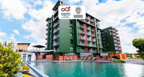 a hotel with a swimming pool in front of a building at SureStay By Best Western Iconic Suvarnabhumi in Samut Prakan