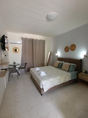 a bedroom with a large bed and a table at Agathi Paradise Studios in Haraki