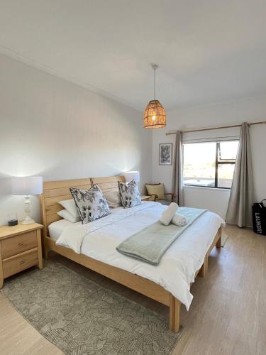a bedroom with a large bed with pillows at Atlantic Apartment - spacious kite accommodation in Langebaan