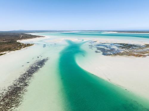 a shadow of a person on a beach at Atlantic Apartment - spacious kite accommodation in Langebaan