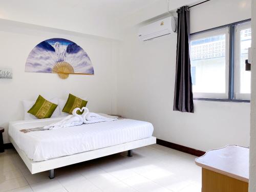 a white bedroom with a bed with a window at Remember at Phuket Town Hostel in Phuket