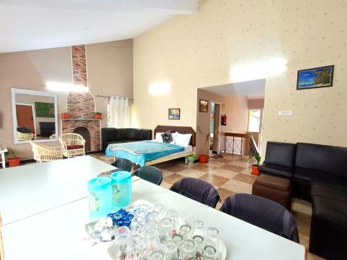 a living room with a table and chairs and a living room at QUEENS COTTAGE - individual cottage in Ooty