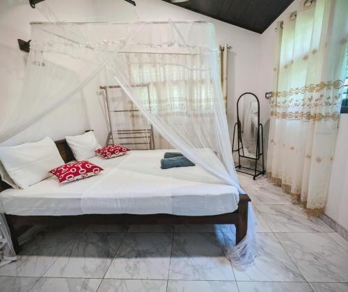 a bedroom with a bed with a canopy at Canopy villas in Mirissa