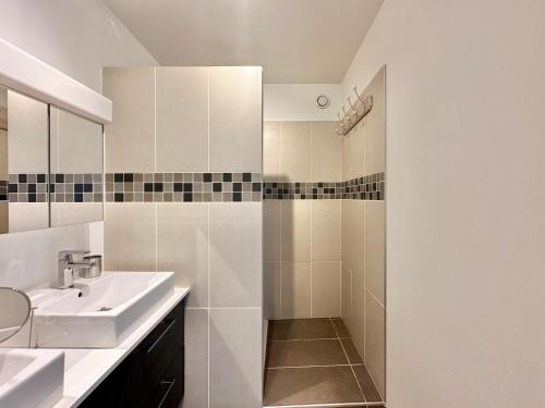 a white bathroom with a sink and a shower at Le Gémeaux - Paris - La Défense vue d'exception in Courbevoie