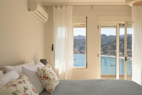 a bedroom with a bed with a view of the ocean at Nere Suites in Lygaria