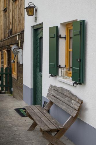 a wooden bench sitting outside of a building with green shutters at ZumSchutzpatron in Bschlabs