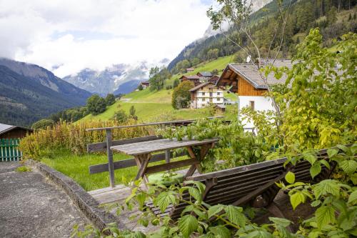 a picnic table in a field with mountains in the background at ZumSchutzpatron in Bschlabs