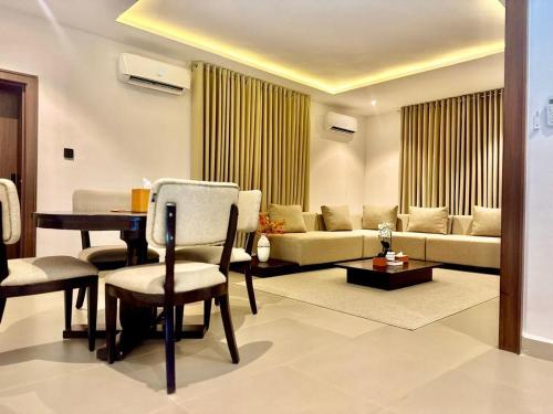 una sala de estar con una mesa y un sofá en 1260 Lumaana Residence, en Garki