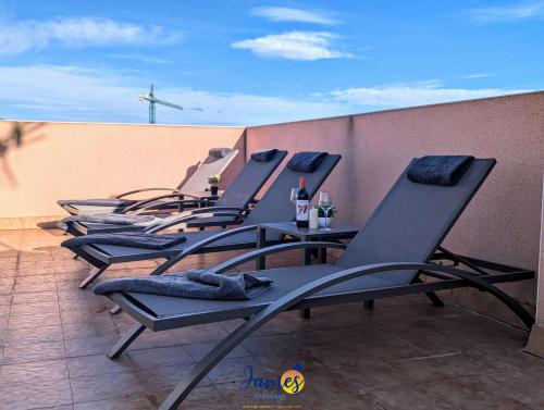 VillacostaにあるContemporary 2 Bed Apartment with Com Pool VM77のバルコニーに置かれた長椅子の列