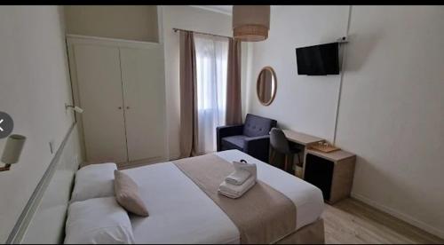 a bedroom with a bed and a chair and a television at Ura Hotel Boutique Gurea in Las Palmas de Gran Canaria