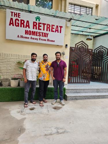 a group of three men standing in front of a sign at The Agra Retreat-walk to the Taj Mahal in Agra