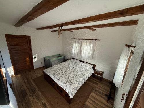a bedroom with a bed and a wooden floor at Casutele de Poveste in Brădetu