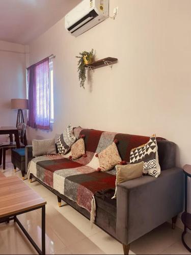 a living room with a couch with pillows on it at Modern 2BHK Hideout in Benaulim in Benaulim