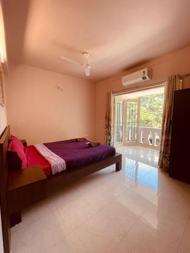 a bedroom with a bed and a large window at Modern 2BHK Hideout in Benaulim in Benaulim