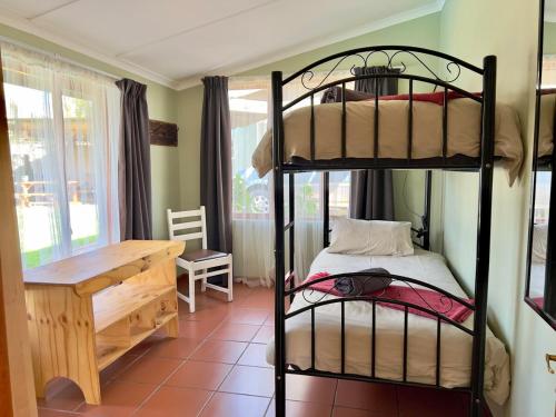 a bedroom with two bunk beds and a desk at Tuinhuis in Oudtshoorn