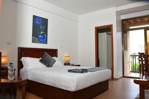 a bedroom with a bed with a blue vase on the wall at Sun View Hotel in Addis Ababa