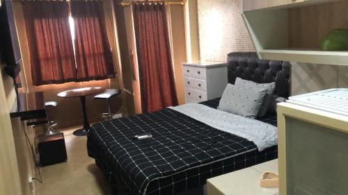 a small bedroom with a bed with a black blanket at DN property in Bandung