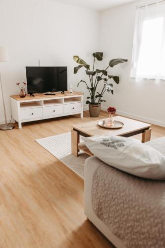a living room with a flat screen tv and a couch at Ferienwohnung Maria in Herten