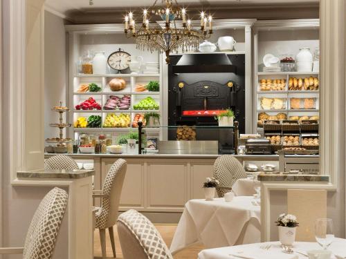 Un restaurante con mesas y sillas en una cocina. en Fairmont Hotel Vier Jahreszeiten, en Hamburgo