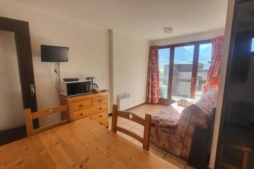 a small living room with a bed and a window at Nice studio near the ski lift in Briançon