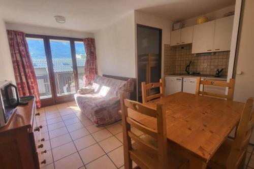 a kitchen and living room with a table and a kitchen and a table and chairs at Nice studio near the ski lift in Briançon